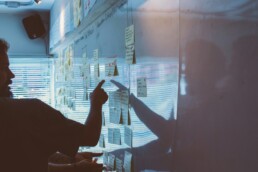 A man using sticky notes and a board to visualize and prepare for portfolio rebalancing.