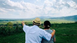 An older couple in a field, enjoying retirement after estate planning.