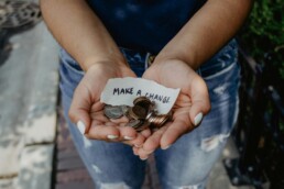 A pair of hands holding several coins to represent impact investing and how it inspires change