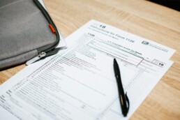 A desktop with a tax deduction form and pen laying atop