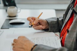 A person sitting at a desk and looking over a ledger to determine capital gains tax