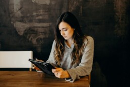 A woman using a tablet to manage unexpected expenses.