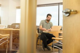 A man sitting at a desk, reviewing his passive income streams.