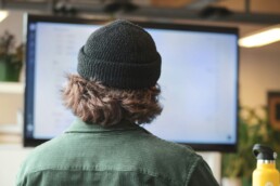 A man sitting in front of his computer monitor, taking cybersecurity steps.